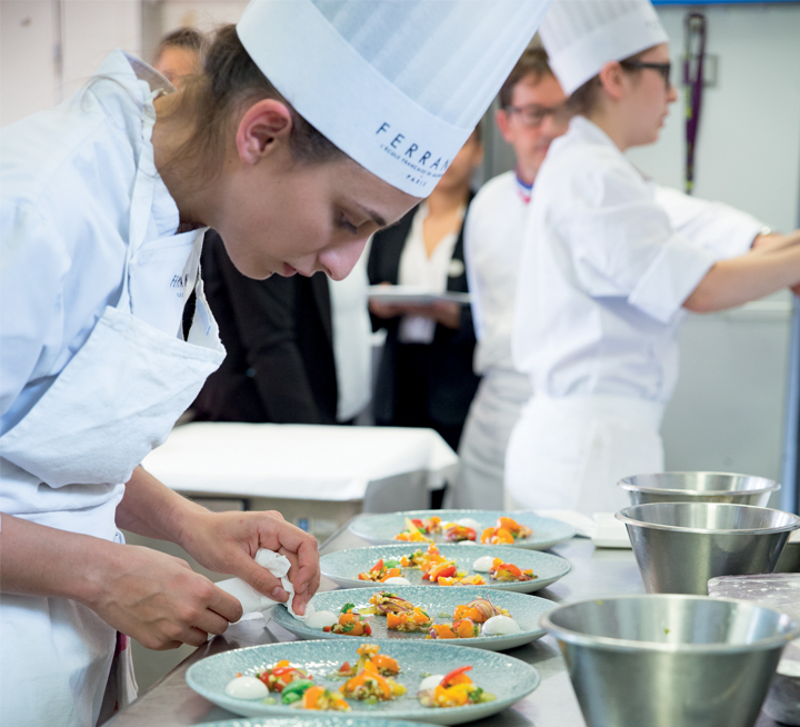 Jeune femme en apprentissage dans les cuisines de FERRANDI Paris